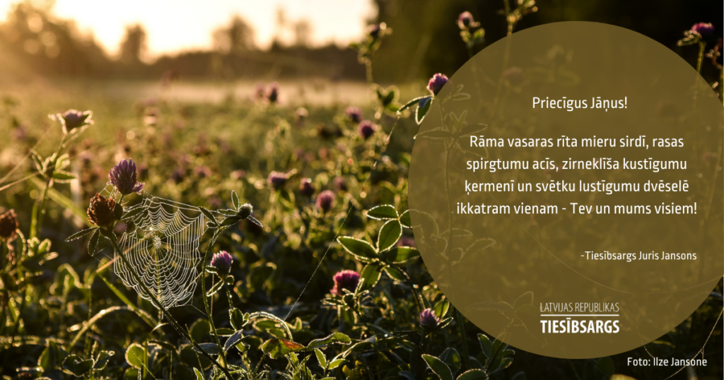 Attēlā āboliņu pļāva saullēktā, zirnekļtīkls, kurš skaisti saules staru izgaismots. Teksts: Priecīgus Jāņus! Rāma vasaras rīta mieru sirdī, rasas spirgtumu acīs, zirneklīša kustīgumu ķermenī un svētku lustīgumu dvēselē ikkatram vienam - Tev un mums visiem! Tiesībsargs Juris Jansons. Attēla autore - Ilze Jansone