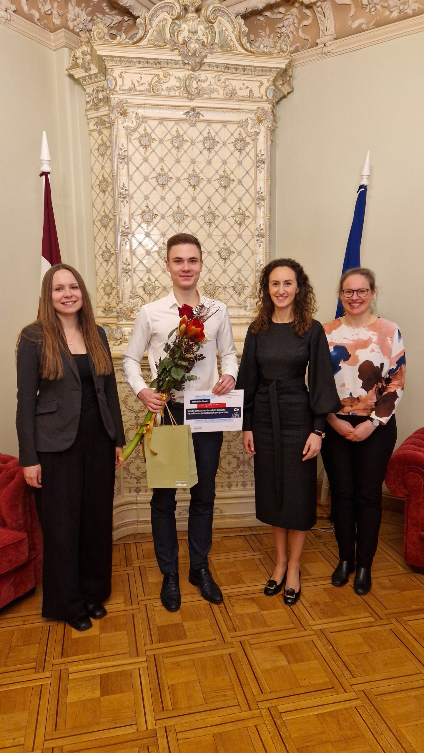 Karina Palkova, Arina Melse un Ieva Šņepste sveic 3. vietas ieguvēju Ronaldu Gacki